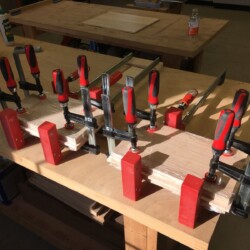 Top and bottom clamped with stretchwrap-covered plywood cauls to keep everything flat.