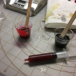 Mixing epoxy resin with red and black opalescent pigments.