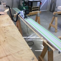 Using the tracksaw to rip a straight edge of some of the lumber.