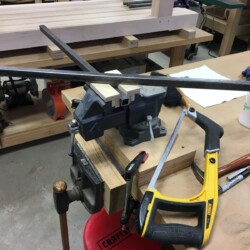 Cutting two 24 inch lengths of square steel tubing to connect retractable caster levers