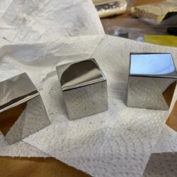 Three highly polished stainless steel cubes
