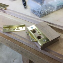 A quick jig with holes drilled to enable locating the mounting holes on the case side of the hinges