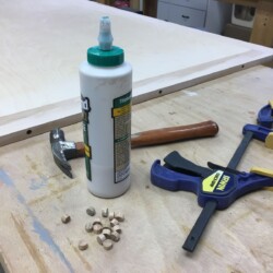 Plugging screw holes in the top maple border with red oak plugs for a little contrast.