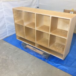 Lower cabinet in spray booth, upside down for first two coats of spray finish.