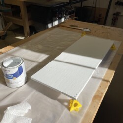 Painter's points support the new refrigerator door as it is being painted.